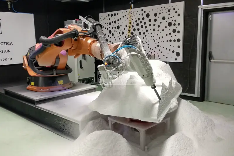 KUKA robot with a spindle carving a large white foam block.